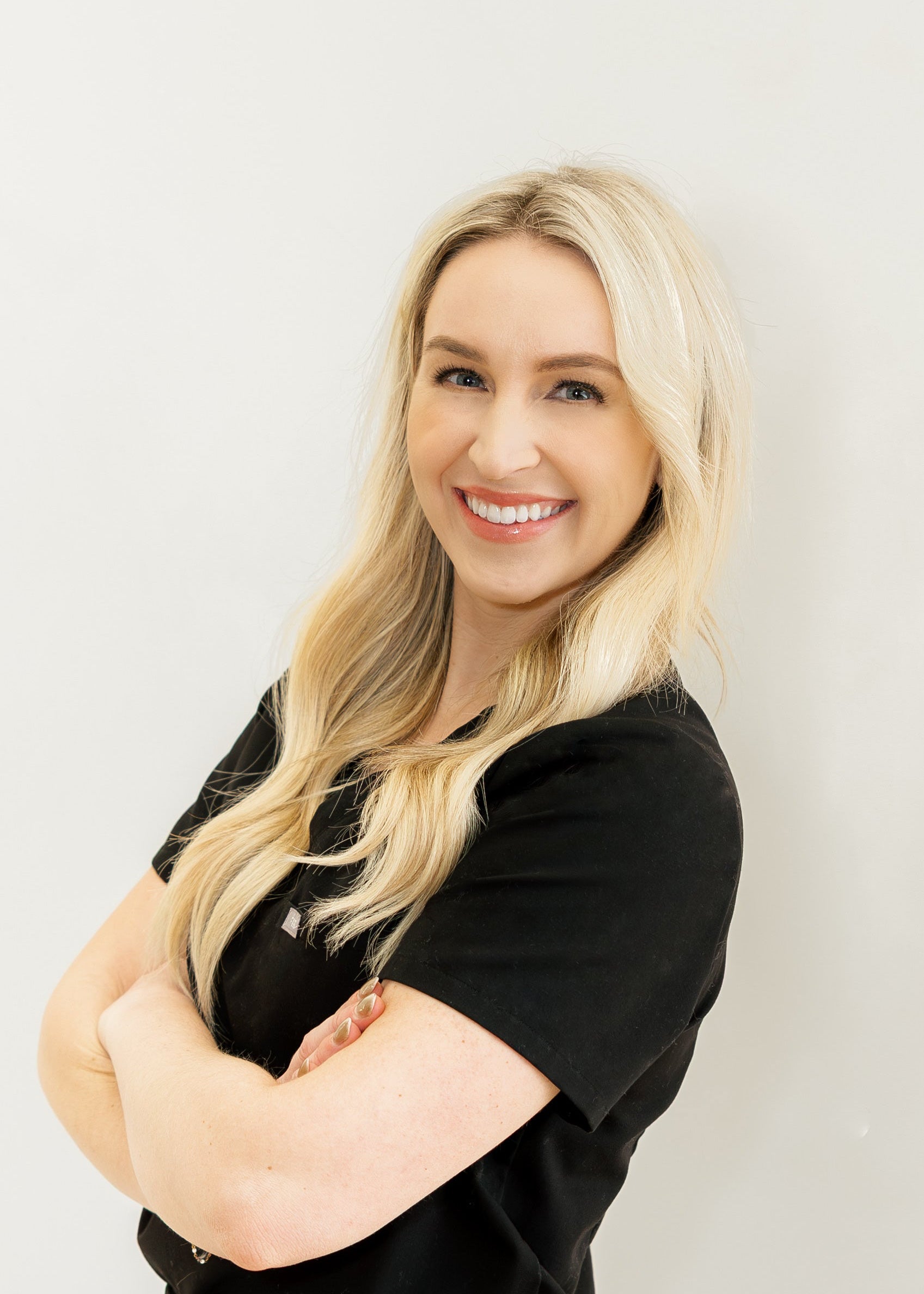 Woman with blonde hair wearing a black shirt against a white background