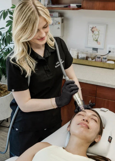 Woman receiving a facial treatment from a professional in a salon setting.
